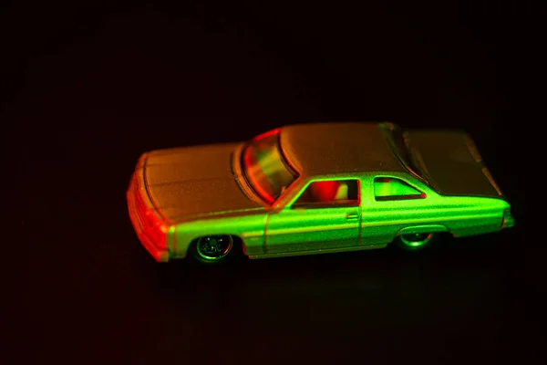 Oyuncak araba kırmızı ve yeşil ışık altında.