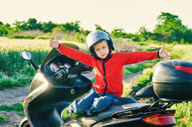 Babasının motosiklet üzerinde oturan çocuk