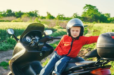 Babasının motosiklet üzerinde oturan çocuk