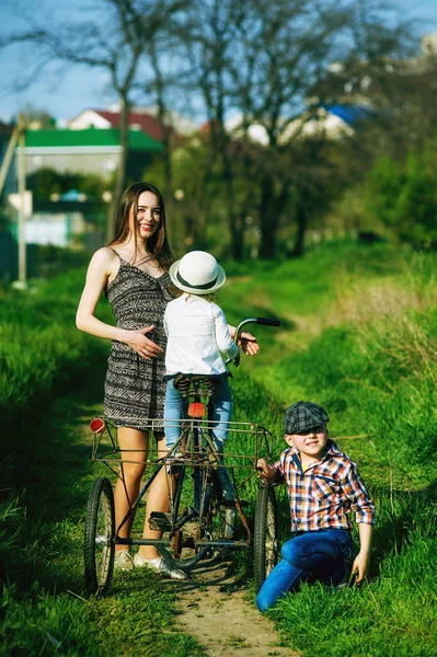 Cheerful family on vacation in the Park with a retro bike