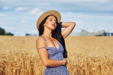 Buğday alanında bir yolda hafif yaz elbiseli Genç romantik kadın