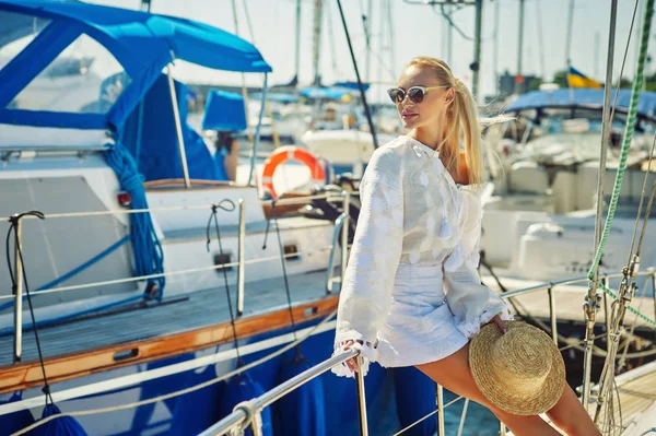 Attractive young woman on a yacht on a summer day. Beautiful fashionable woman in summer outdoors., young happy woman on the background of sea boats.