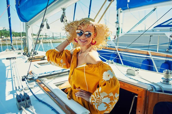 Attractive young woman on a yacht on a summer day. Beautiful fashionable woman in summer outdoors., young happy woman on the background of sea boats.