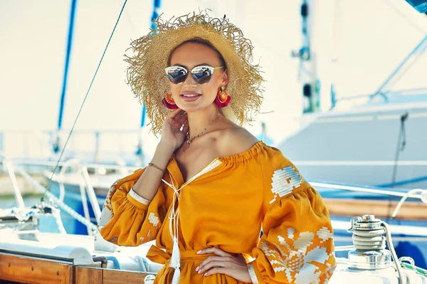 Attractive young woman on a yacht on a summer day. Beautiful fashionable woman in summer outdoors., young happy woman on the background of sea boats.