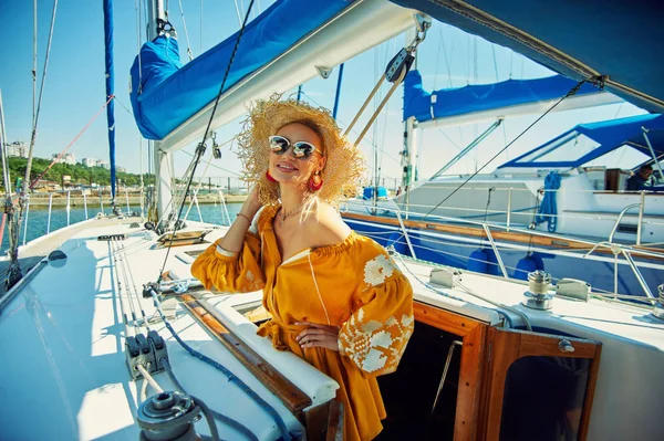 Attractive young woman on a yacht on a summer day. Beautiful fashionable woman in summer outdoors., young happy woman on the background of sea boats.