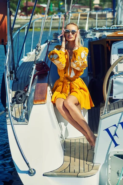 Attractive young woman on a yacht on a summer day. Beautiful fashionable woman in summer outdoors., young happy woman on the background of sea boats.