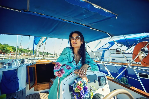 Attractive young woman on a yacht on a summer day. Beautiful fashionable woman in summer outdoors., young happy woman on the background of sea boats.