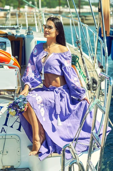 Attractive young woman on a yacht on a summer day. Beautiful fashionable woman in summer outdoors., young happy woman on the background of sea boats.