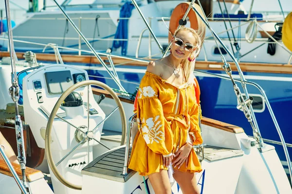 Attractive young woman on a yacht on a summer day. Beautiful fashionable woman in summer outdoors., young happy woman on the background of sea boats.