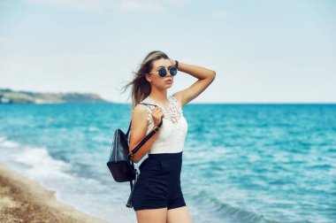 Çekici kız deniz kıyısında. Deniz kenarında yürüyüşe genç şık kadın