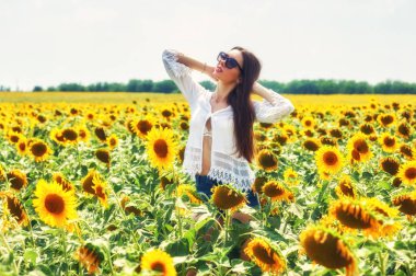 Güzel genç kız açık havada. Genç bir kız alanında çiçekli ayçiçeği ile eğleniyor .