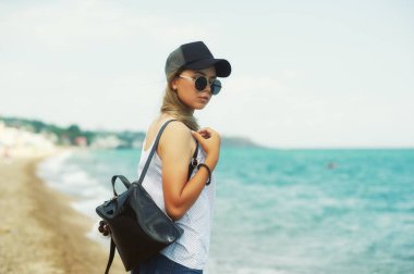 Çekici kız deniz kıyısında. Deniz kenarında yürüyüşe genç şık kadın