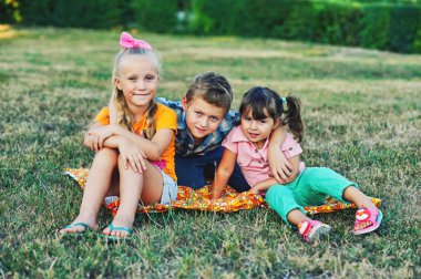 Çimenlerin üzerinde oynayan komik şirin çocuklar. Çocuk arkadaş yürüyüşte eğlenin