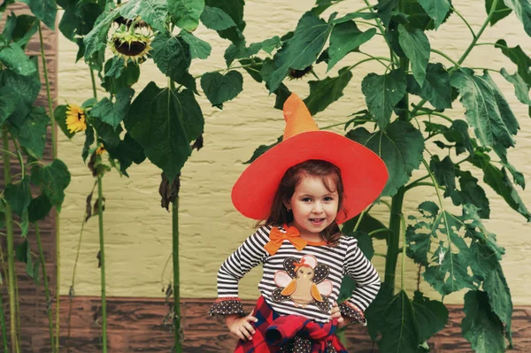 Funny little girl in a hat for Halloween