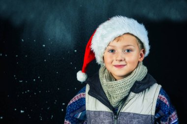 Stüdyo portre neşeli bir çocuk. Çocuk bir sıcak örme kazak ve şapka giymiş