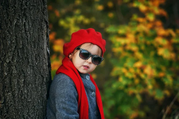 一个小女孩在秋天散步时的肖像 孩子穿着暖和的外套 拿着太阳镜 童装的概念 — 图库照片