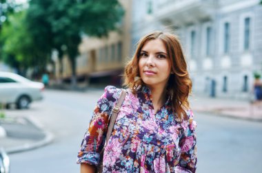 Şehirde bir yolda parlak giysili genç kadın