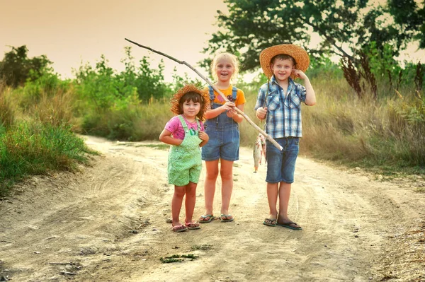 children go fishing, a group of children with a fishing rod and caught river fish on the road