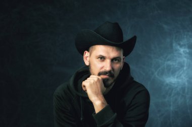 Karanlık bir arka plan üzerinde geniş ekledi şapkalı bir adam portresi stüdyo