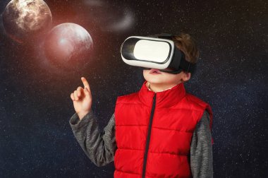 Uzay hakkında bir oyun oynarken sanal bir kulaklık olan bir çocuk. Sanal gerçeklik ve modern teknolojiler
