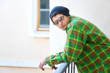 güneş gözlüğü ve ekose gömlek genç adam