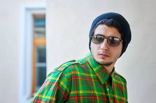 güneş gözlüğü ve ekose gömlek genç adam