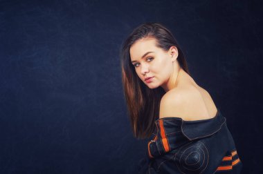 Koyu arka plan üzerinde Studio deri ceketli genç güzel kız