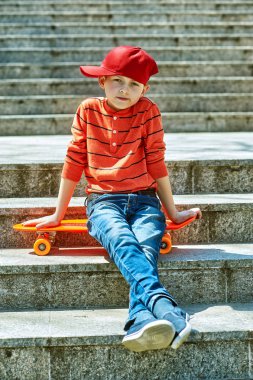 Şehir Parkı'nda kaykaylı bir çocuğun portresi. Çocuk açık hava sporları sonra dinleniyor