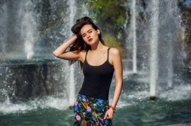 Sokakta genç bir kadının portresi. Sıcak bir bahar gününde poz veren model