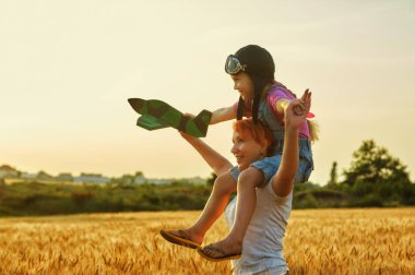 Anne ve kızı bir model uçak ile gün batımında alanında oynarken . Mutlu bir aile. Anneler günü