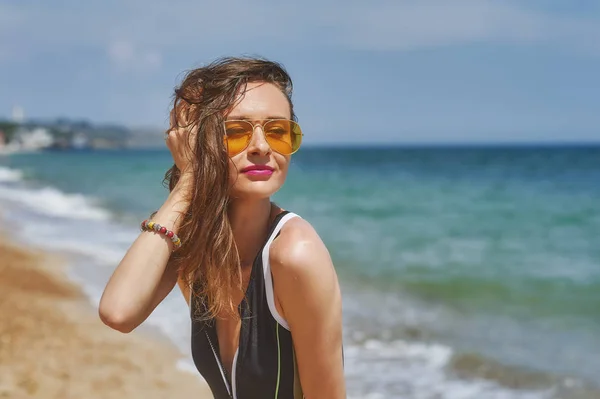 一个年轻女子在海岸上戴着太阳镜的肖像 — 图库照片