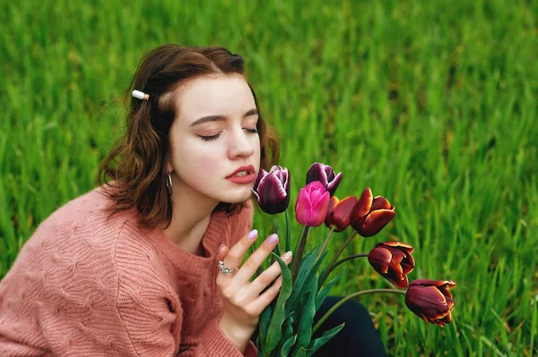 一个美丽的年轻女孩在田野与鲜花的肖像 与郁金香合影的模特 — 图库照片