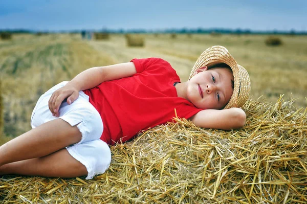 一个小男孩在田里度假的肖像 躺在马槽里的孩子 — 图库照片