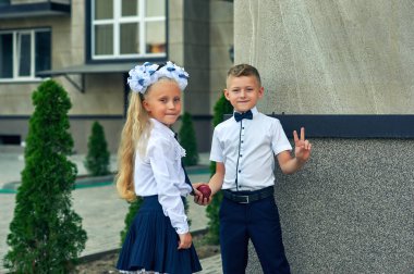 Teneffüste ilkokul öğrencileri . Okula geri dön, sonbaharın ilk günü. Güzel erkek ve kız okul üniforması