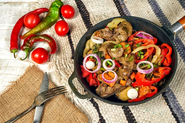 Chicken fried liver with vegetables at home in a frying pan