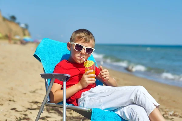 Chłopiec Odpoczywa Wybrzeżu Morza Dziecko Siedzi Krześle Plażowym Trzymając Szklankę — Zdjęcie stockowe