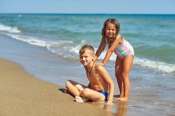 Neşeli çocuklar deniz kıyısında dinlenmek. Çocuk yaz tatili