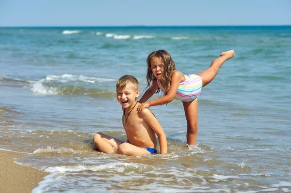 Cheerful children relax on the sea coast . Children\'s summer vacation