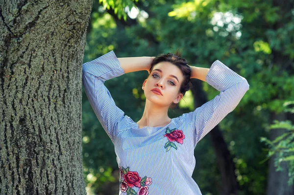 公园里一个年轻漂亮的女孩的肖像 这个女孩穿着一件条纹上衣 — 图库照片