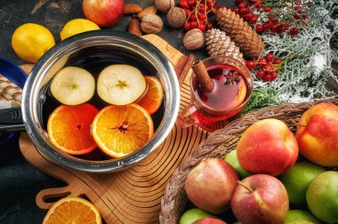 Noel içeceği ahşap bir masada şarap, meyve ve baharatlar.