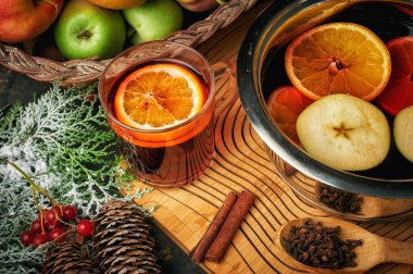 Noel içeceği ahşap bir masada şarap, meyve ve baharatlar.