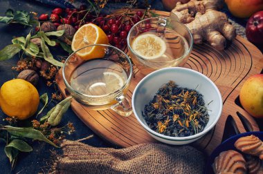 Zencefil, limon, tarçın ve limonlu iki fincan şifalı bitki çayı. Tonik ve terapi amaçlı sıcak içecekler. .