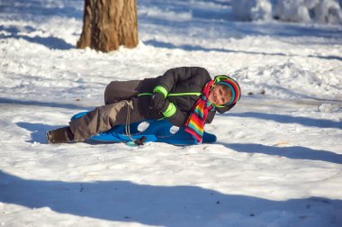 Güneşli bir günde Parkta kış yürüyüşüne çıkan neşeli çocuk.