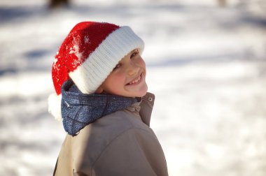 Güneşli bir günde Parkta kış yürüyüşüne çıkan neşeli çocuk.