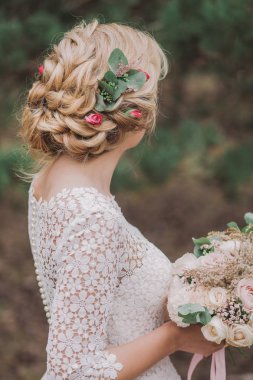 Arka yan görünümü ile mükemmel saç taze çiçeklerle süslenmiş güzel sarışın genç gelin portresi. Dikey renkli fotoğraf.