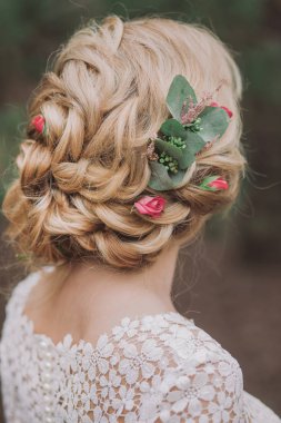 Açık havada duran güzel sarışın gelinin closeup arkadan görünüm. Pastel renkler saç taze çiçeklerle süslenmiş. Dikey renkli fotoğraf.