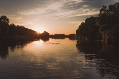 Altın büyüleyici sakin kırsal manzara nehir su üzerinde yumuşak gündoğumu ile. Güzel güneşli doğa yaz arka plan. Yatay renkli fotoğraf.