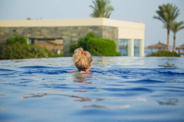 Dan tropikal otel Resort açık havuz mavi su yüzme beyaz Avrupalı turist arkasında görüntüleyin. Su hattı ve vücut su altında tek başına. Yatay renkli fotoğraf.