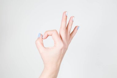 Beyaz el Beyaz arka plan üzerinde izole ok jest olarak closeup görünümü. Tırnaklara sahip modern jel beyaz ve mavi renklerin manikür Lehçe.