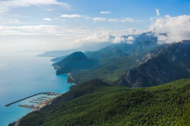 Türk deniz manzara güzel güneşli hava görünümünü. Pitoresk yeşil dağlar ve tepeler üzerinde kabarık beyaz bulutlar. Büyüleyici doğa arka plan. Antalya şehir. Yatay renkli fotoğraf.